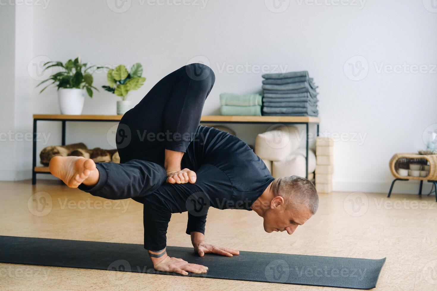 An athletically built man does yoga in the gym on a mat photo