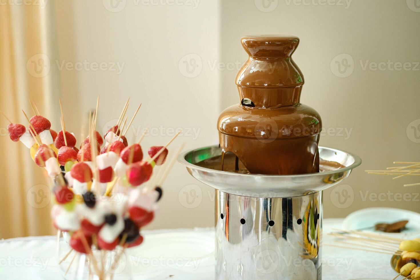 Fondue with a chocolate fountain and sweets for it.Sweet theme photo