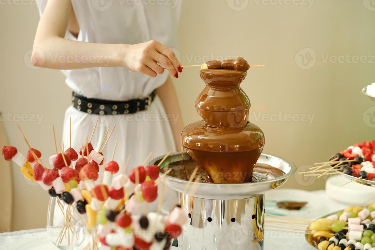 Fondue with a chocolate fountain and sweets for it.Sweet theme photo