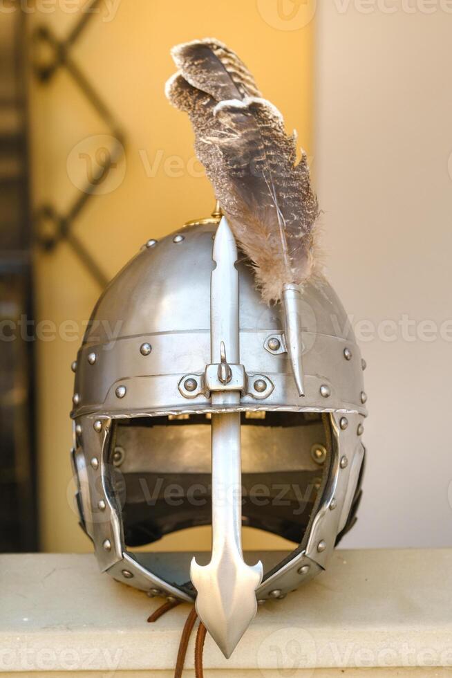 An ancient knight's helmet with a feather .Medieval concept photo
