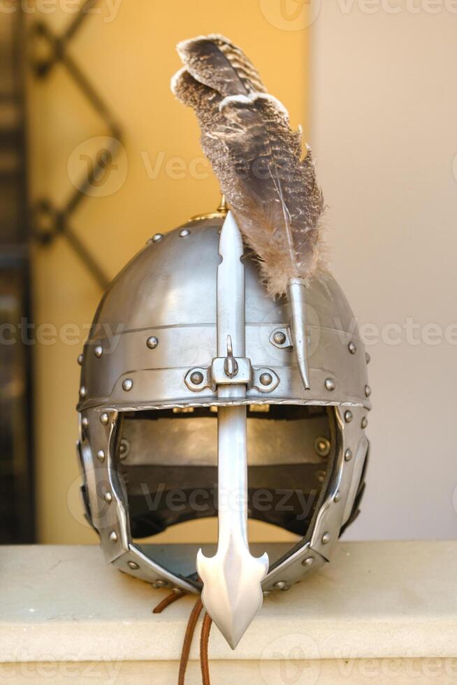 An ancient knight's helmet with a feather .Medieval concept photo
