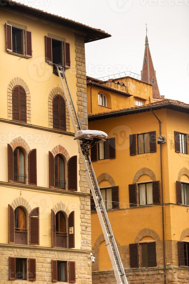 Lifting cargo to the top floor using a large staircase in the center of Florence.Italy.Tuscany photo
