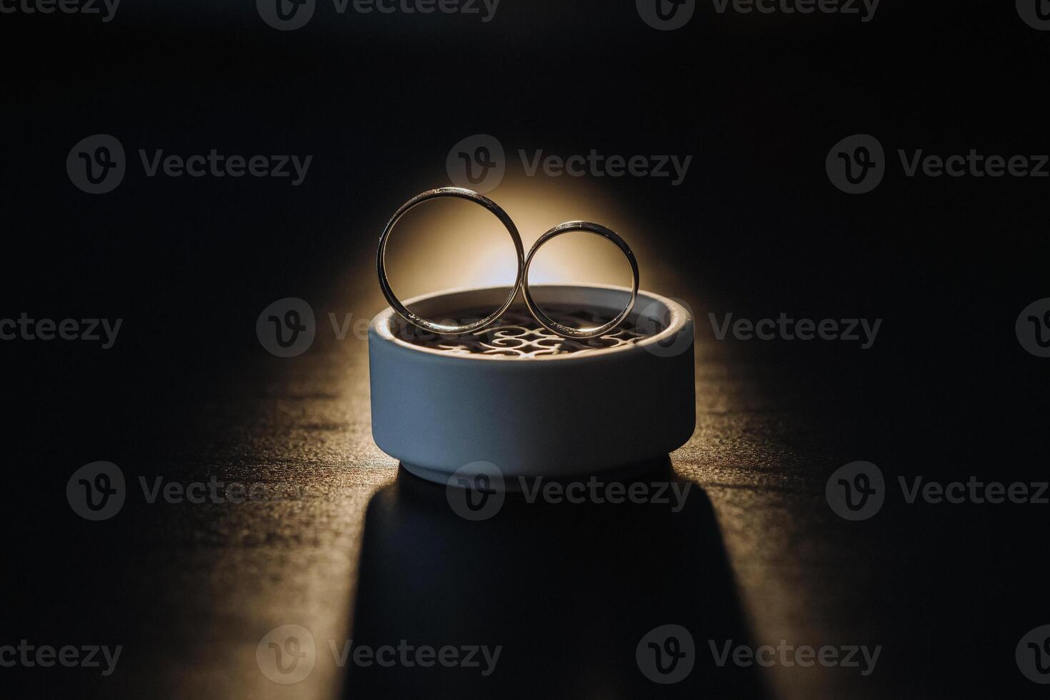 two gold wedding rings in a white box on a black background photo