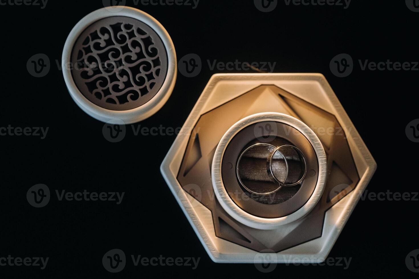 two gold wedding rings in a white box on a black background photo