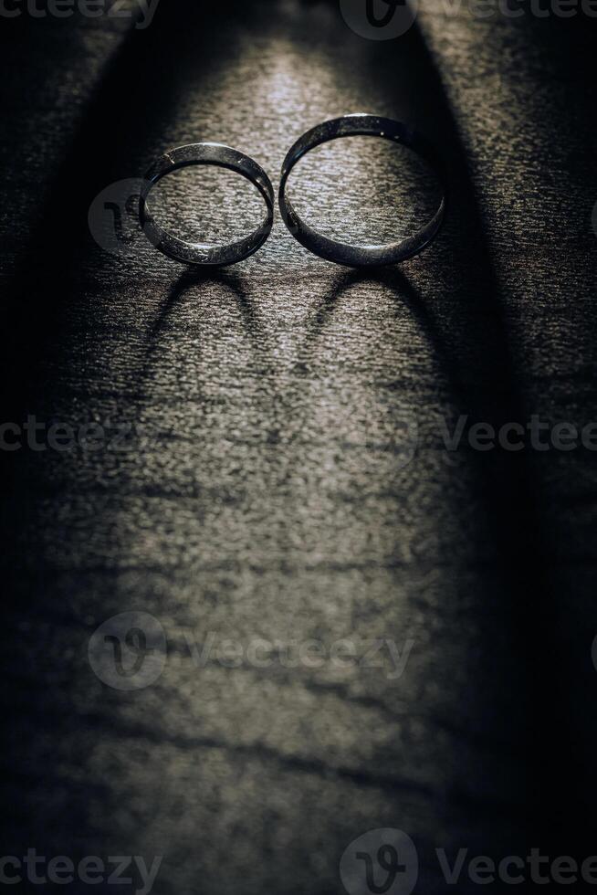 Close-up of two gold wedding rings on a black background photo
