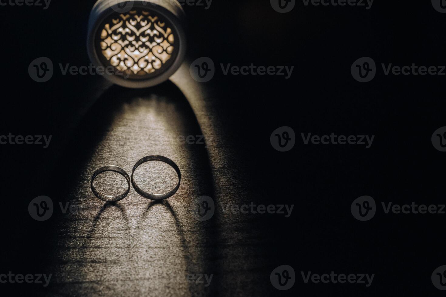 Close-up of two gold wedding rings on a black background photo