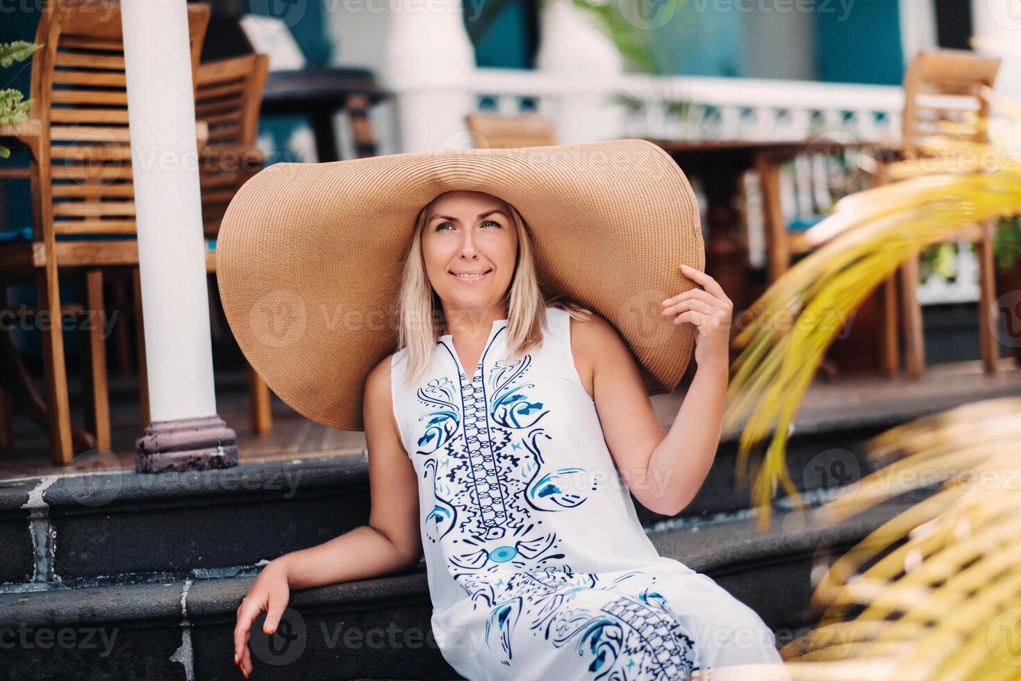 A woman in a large hat and long dress poses on the island of Mauritius. beautiful girl resting on the island of Mauritius photo