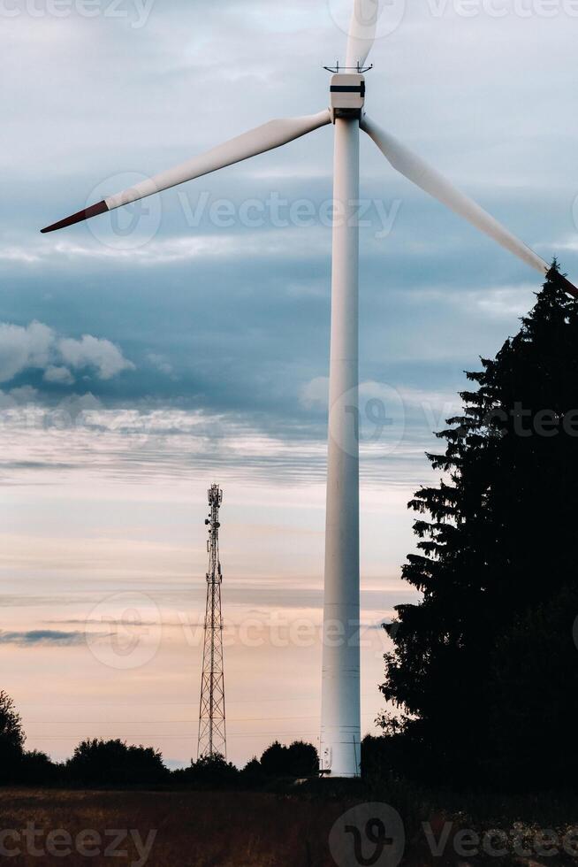 White Windmill against the sunset sky. Windmill in nature photo