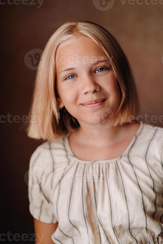 A happy child, a little girl in a gray T-shirt on a beige background photo