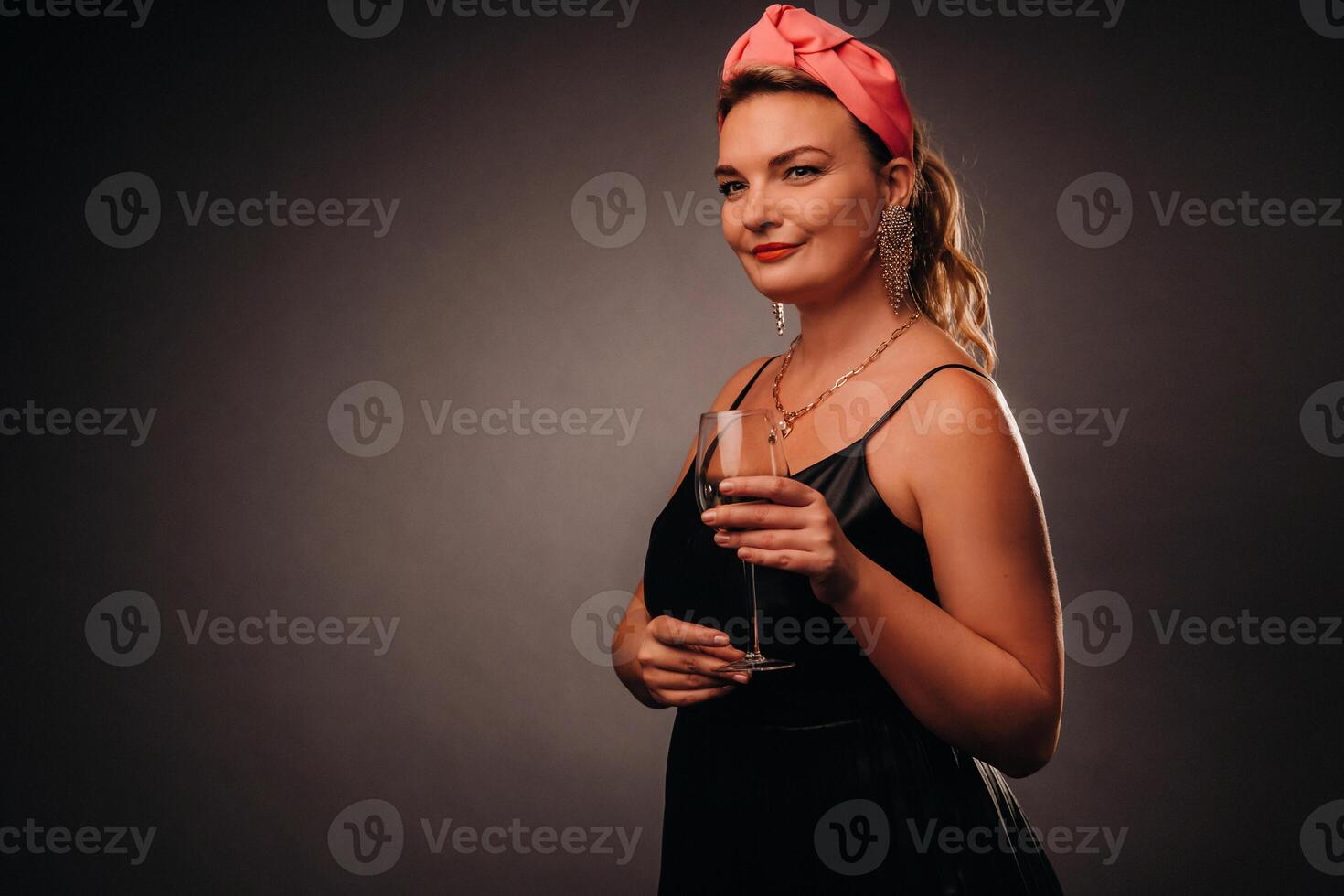 a woman in a black dress holding a glass of champagne on a black background, Christmas, holiday photo