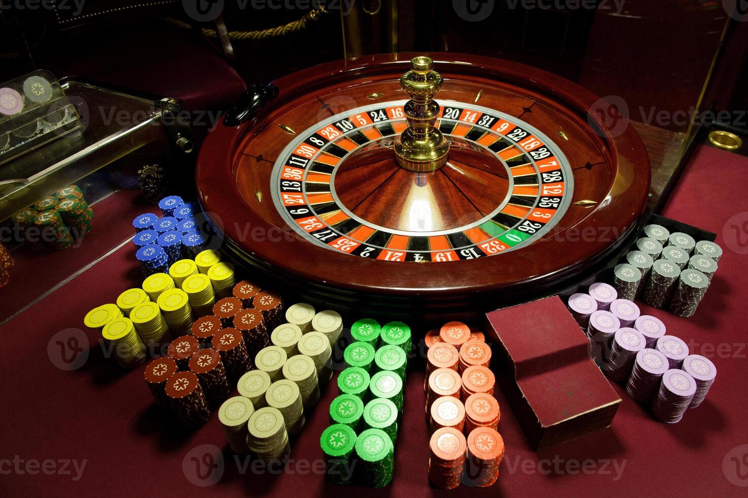 There is a red table with roulette chips in the casino photo