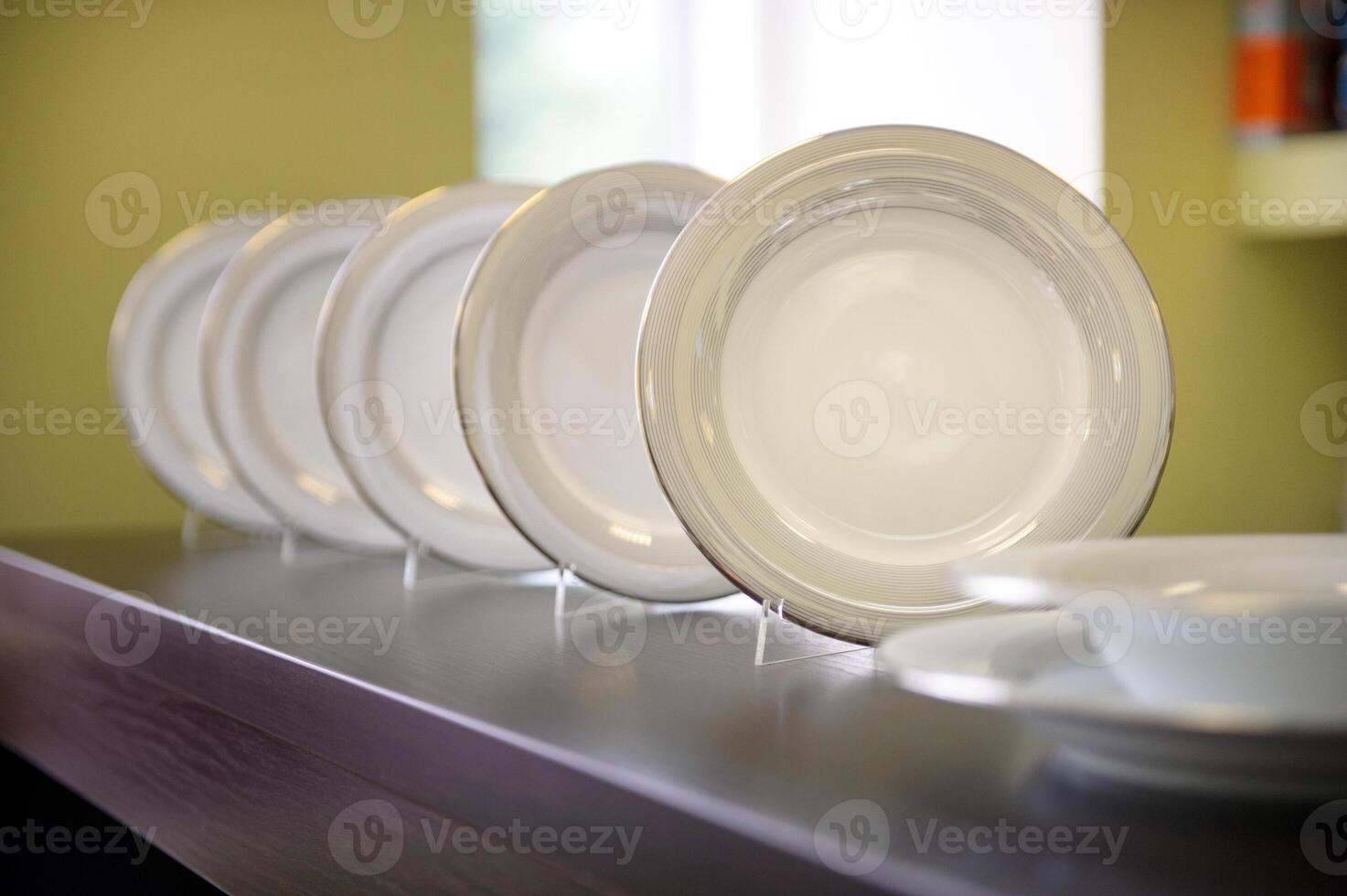 there are many white ceramic plates on the shelf photo