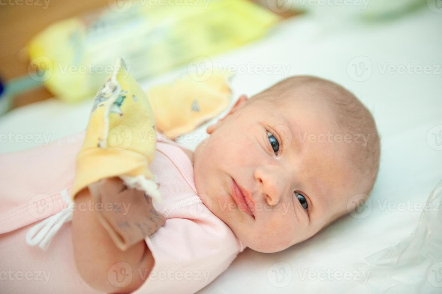 a newborn baby on the first day of its birth in the maternity hospital photo