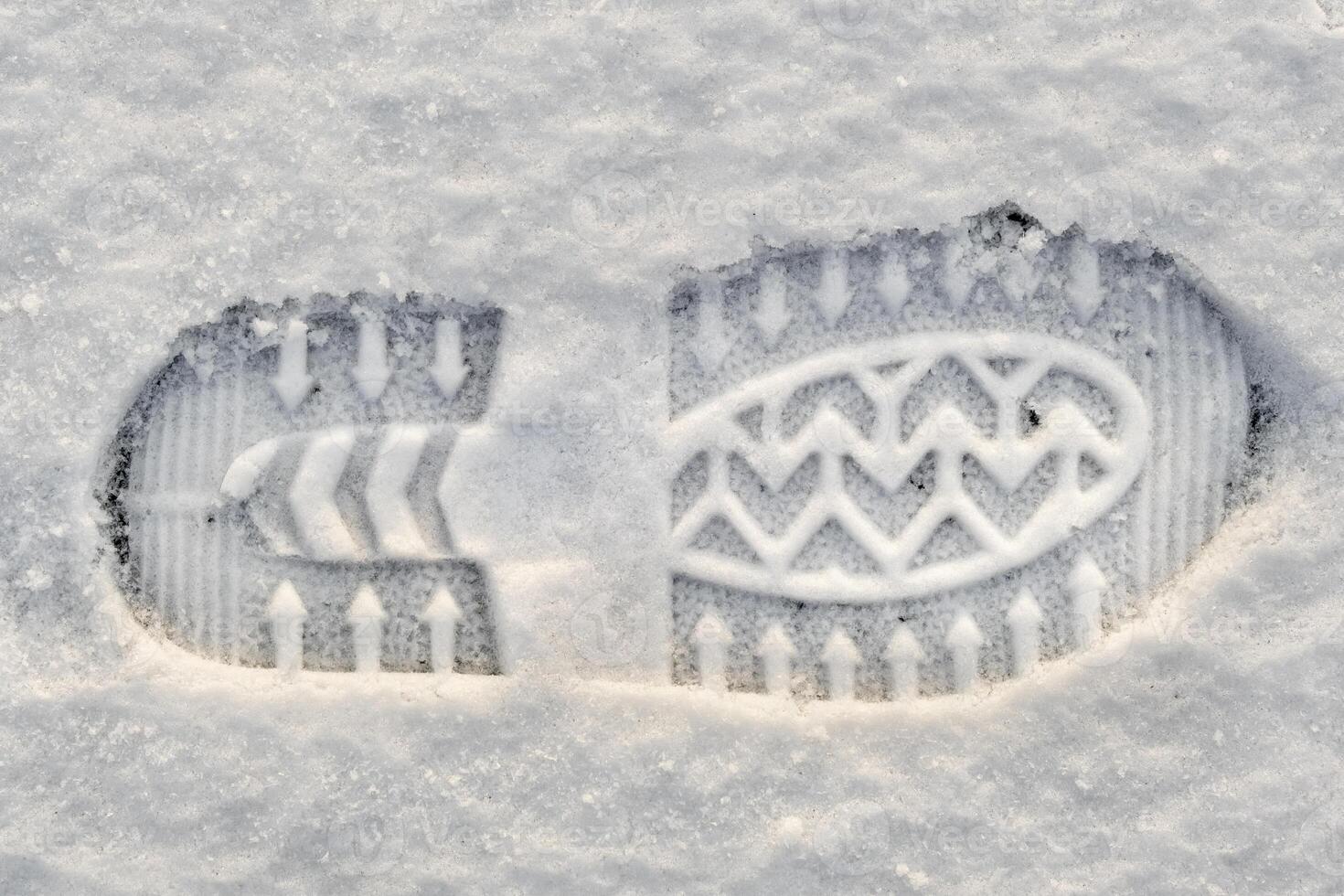 Close-up of a shoe print in the snow, top view of a boot footprint photo