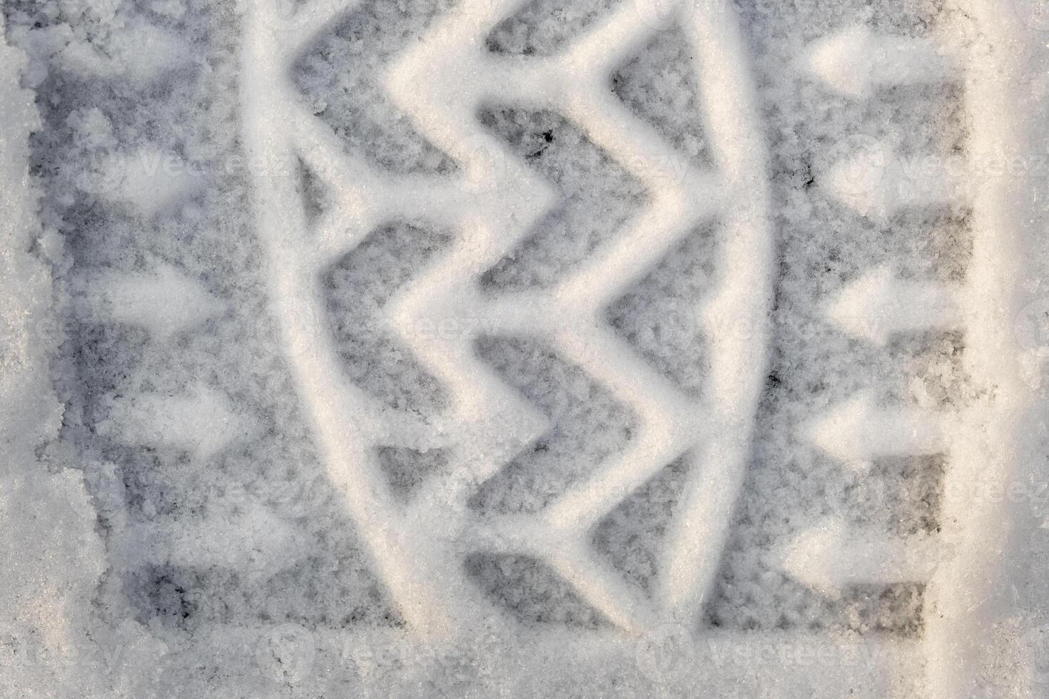 Close-up of a shoe print in the snow, top view of a boot footprint photo