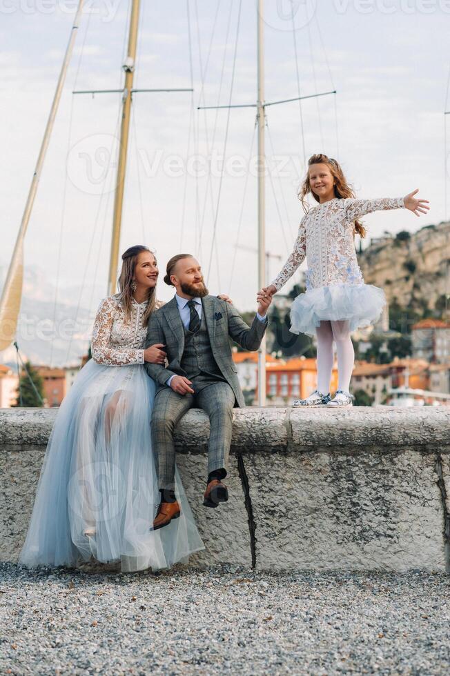 Italy, Lake Garda. Beautiful family on the shores of lake Garda in Italy at the foot of the Alps. Father, mother and daughter in Italy photo