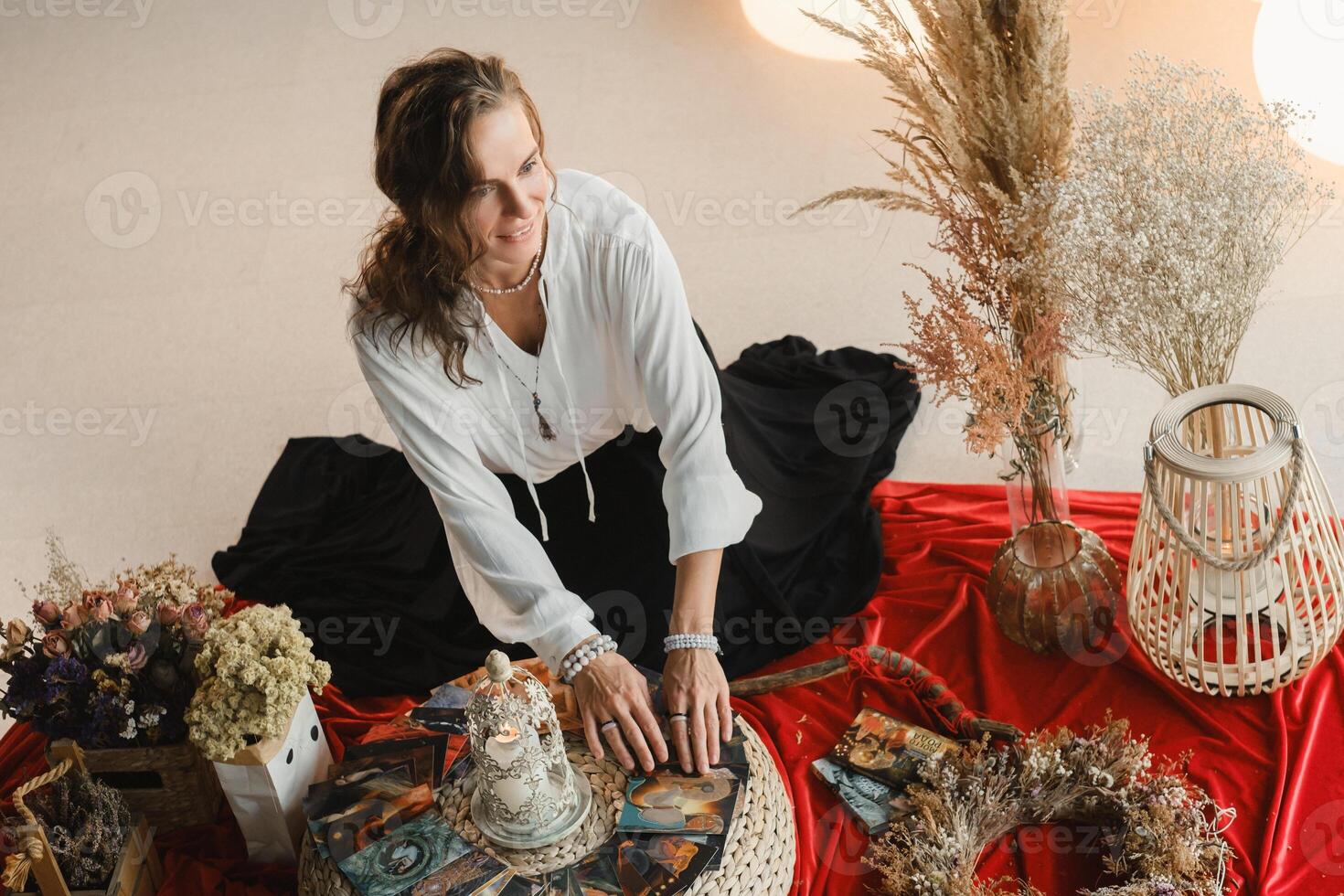Women's circle and practice in the use of metaphorical cards. The girl is sitting surrounded by flowers photo