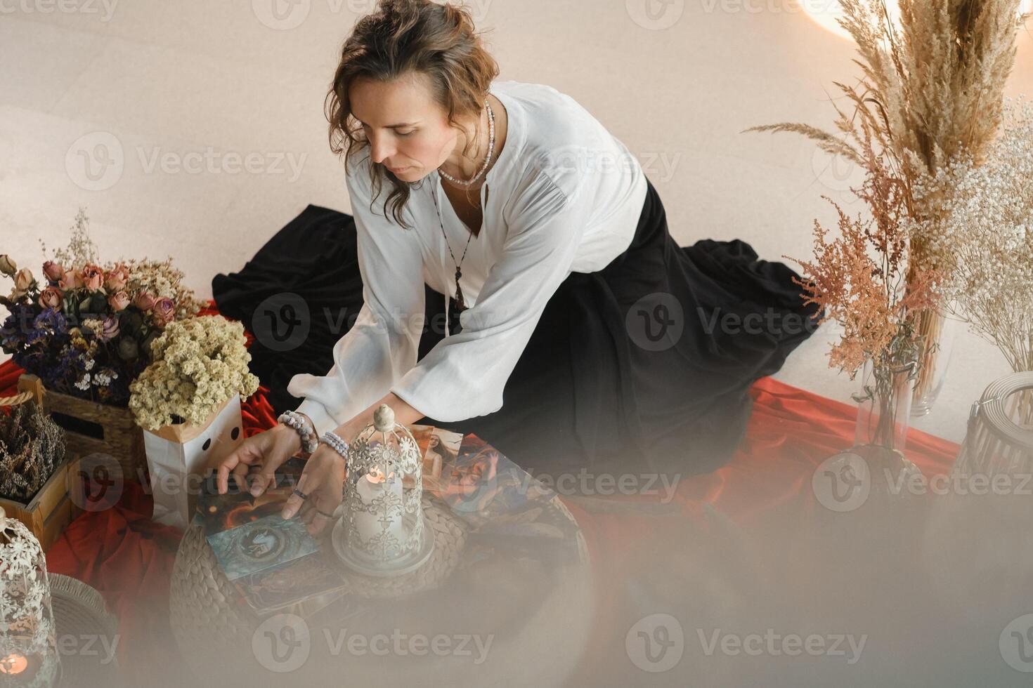 Women's circle and practice in the use of metaphorical cards. The girl is sitting surrounded by flowers photo