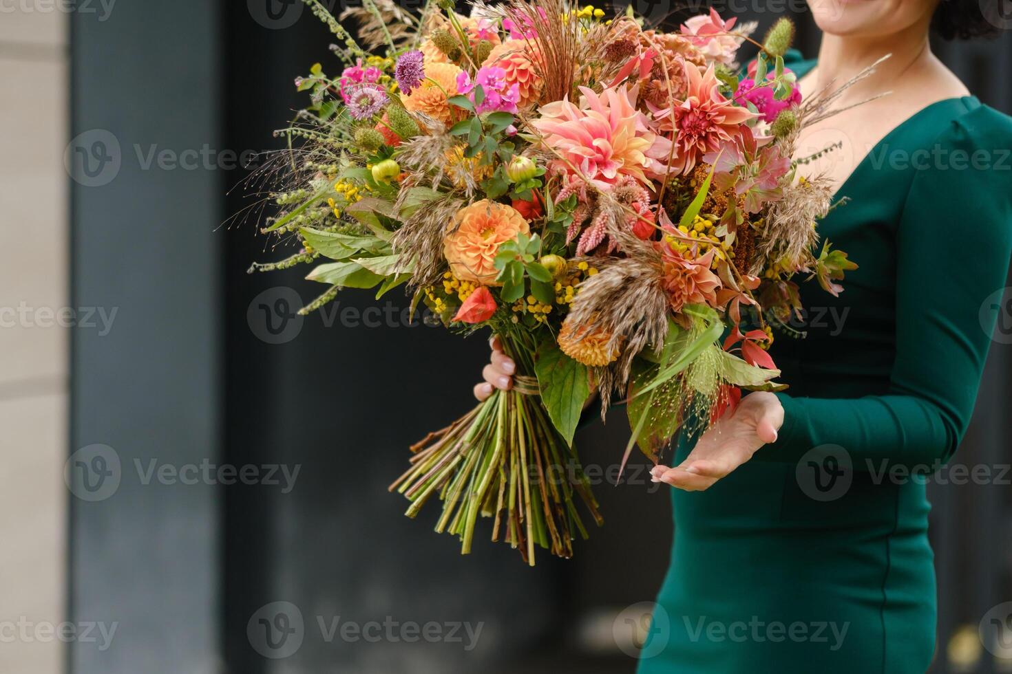A large bouquet of mixed flowers in the hands of a woman. The work of a florist in a flower shop photo