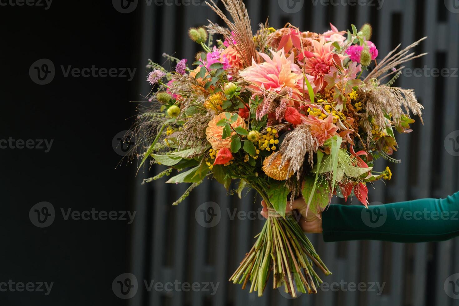 A large bouquet of mixed flowers in the hands of a woman. The work of a florist in a flower shop photo