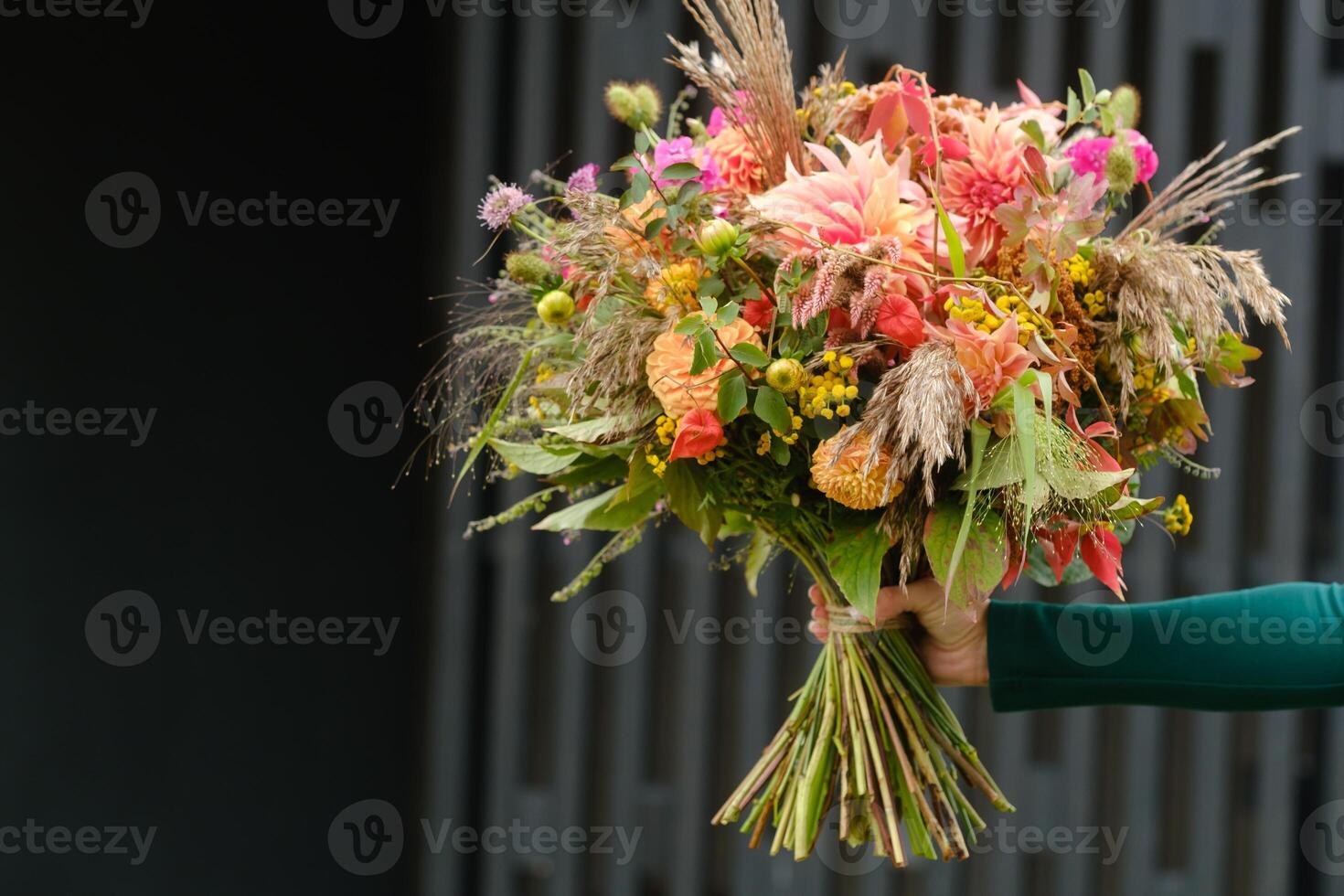 A large bouquet of mixed flowers in the hands of a woman. The work of a florist in a flower shop photo