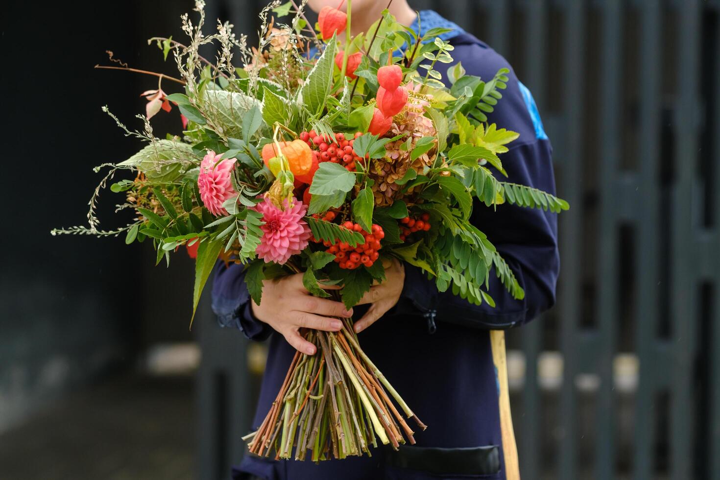 A large bouquet of mixed flowers in the hands of a woman. The work of a florist in a flower shop photo