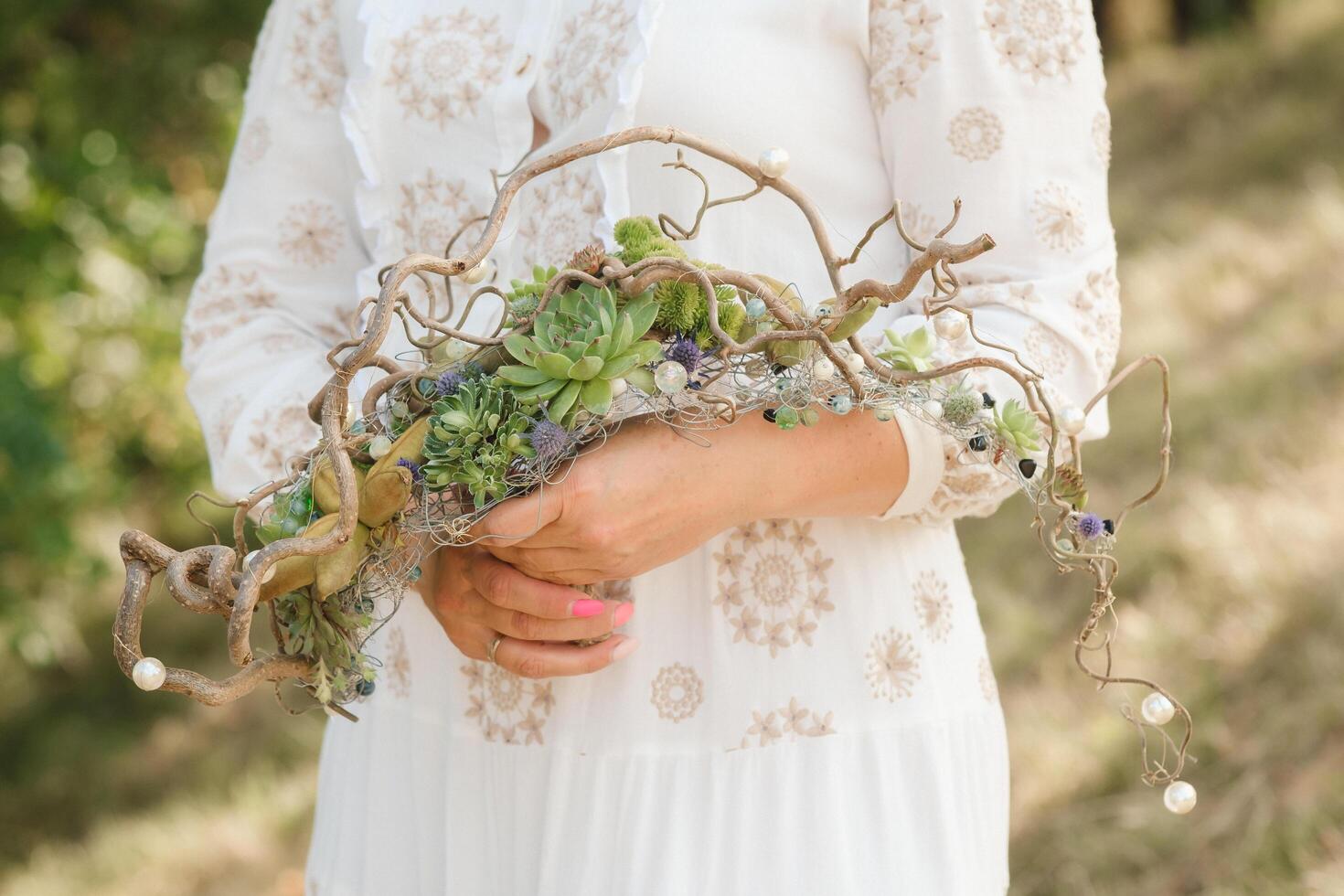 The bride holds an unusual braided wedding bouquet in her hands photo