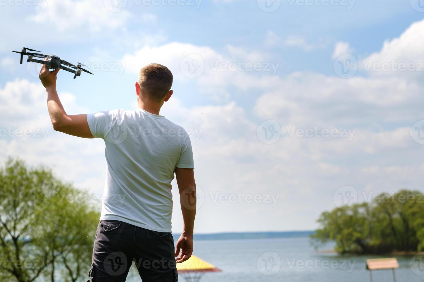 A man with a flying vehicle in his hands, raised to the sky in nature.Launching a drone photo