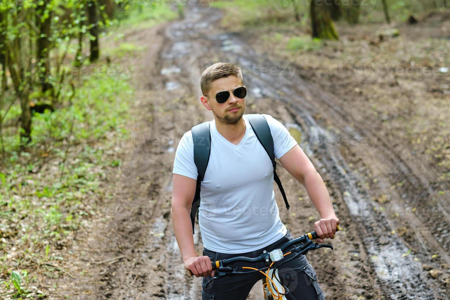 A group of cyclists with backpacks ride bicycles on a forest road enjoying nature photo