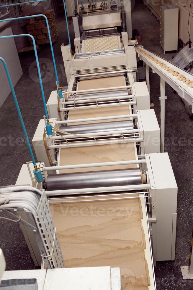 machine for making cookies in the factory. Conveyor belt with Cookie dough photo
