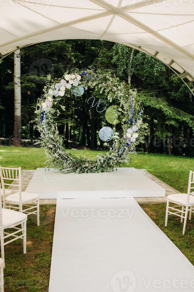 Wedding ceremony on the street on the green lawn.Decor with fresh flowers arches for the ceremony photo