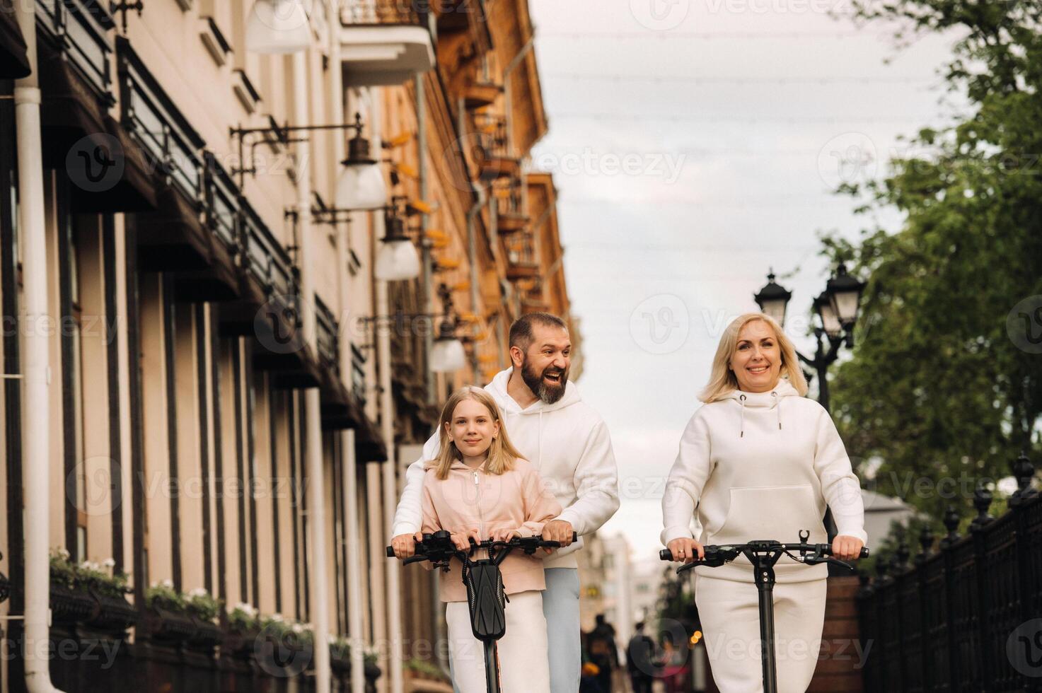 A family in white clothes rides electric scooters in the city.Outdoor activities photo