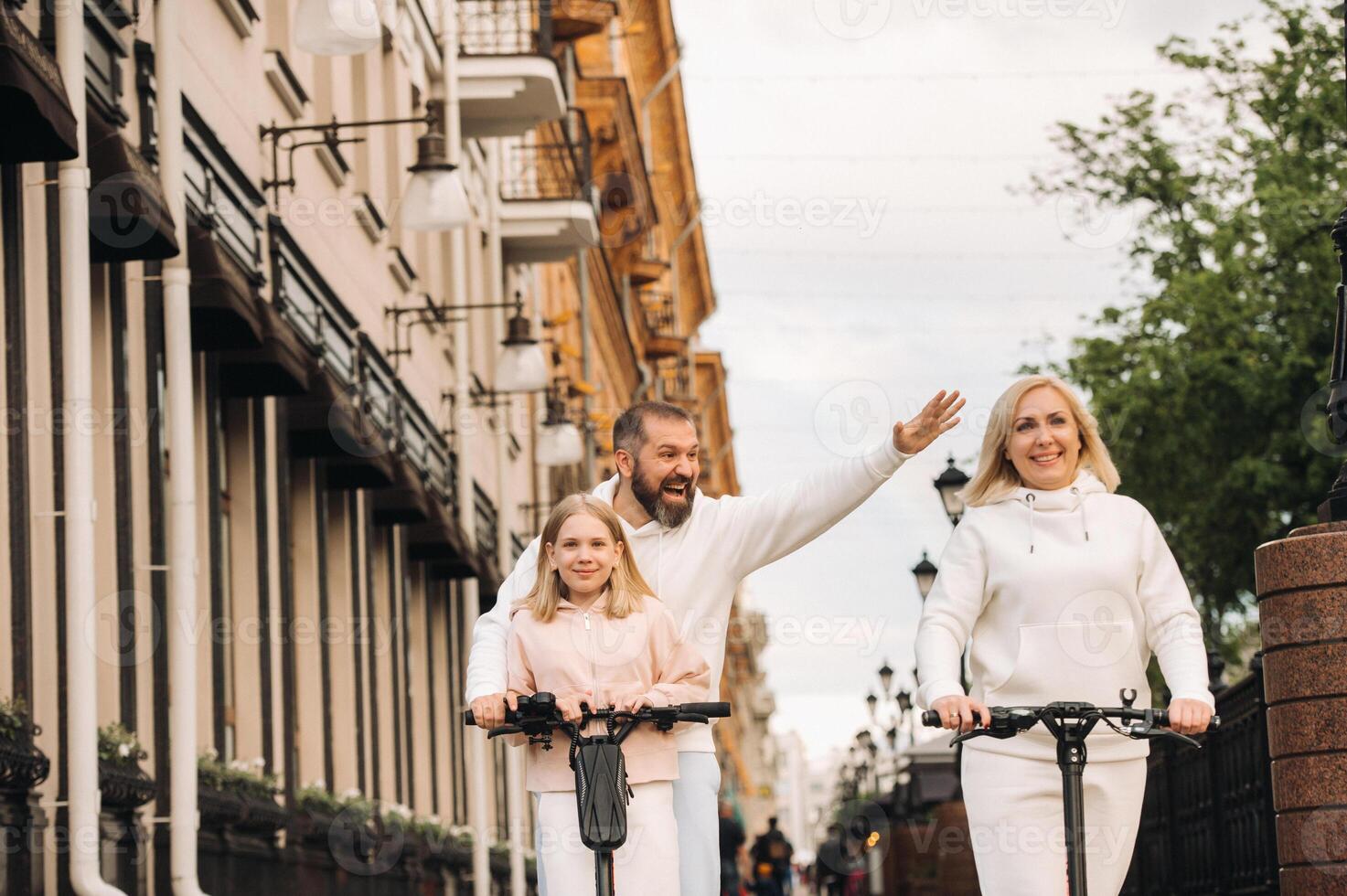 A family in white clothes rides electric scooters in the city.Outdoor activities photo