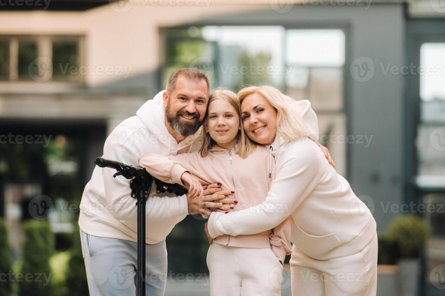 A family in white clothes stands in the city on electric scooters photo