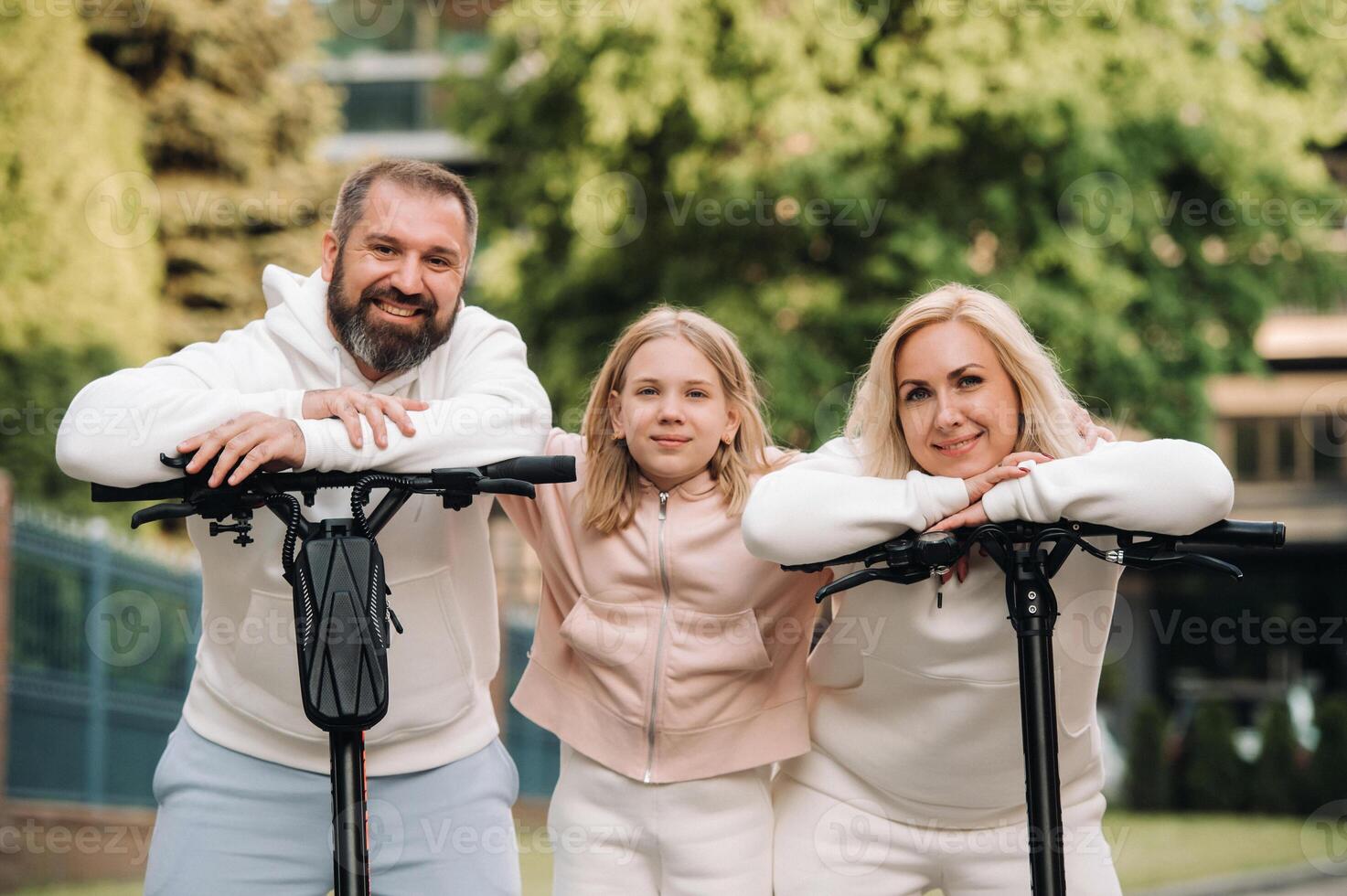 A family in white clothes stands in the city on electric scooters photo