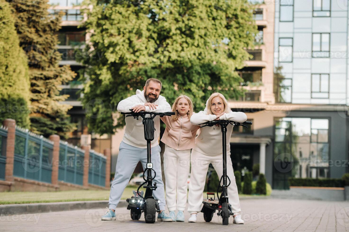 A family in white clothes stands in the city on electric scooters photo