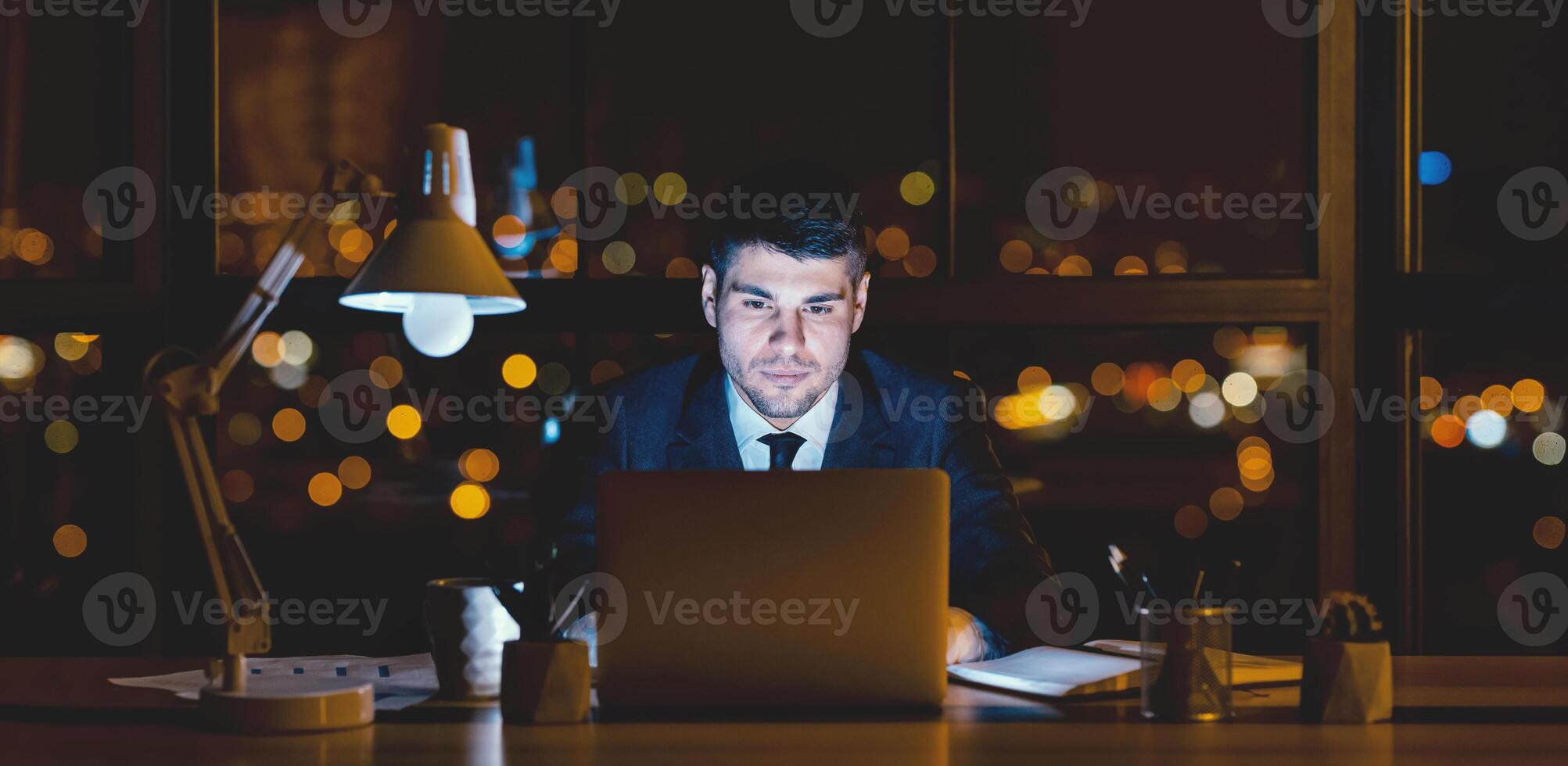 Successful Businessman. Confident Entrepreneur At Laptop Working Online Sitting In Modern Office At Night. photo