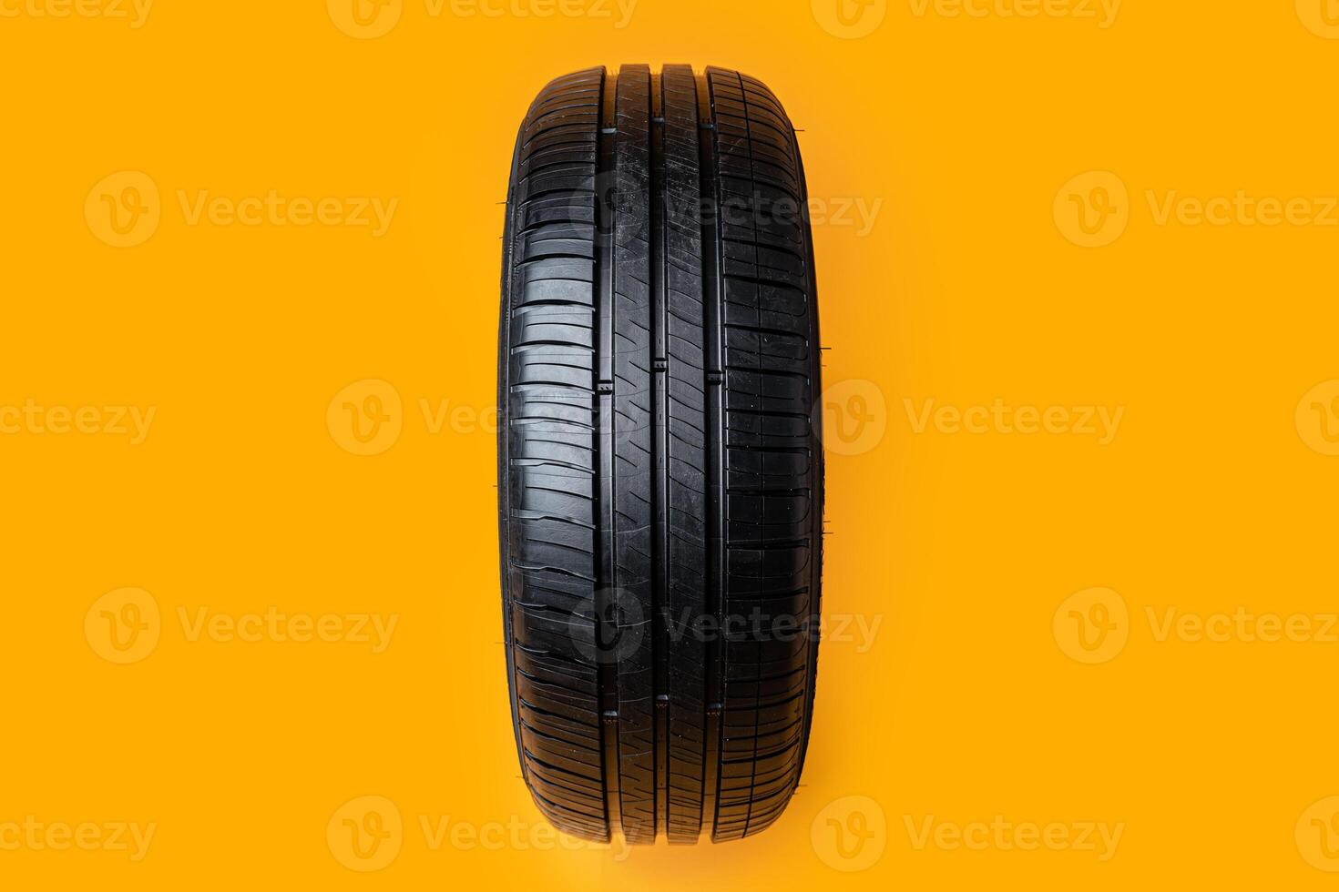 Car tires isolated on yellow background, close up photo