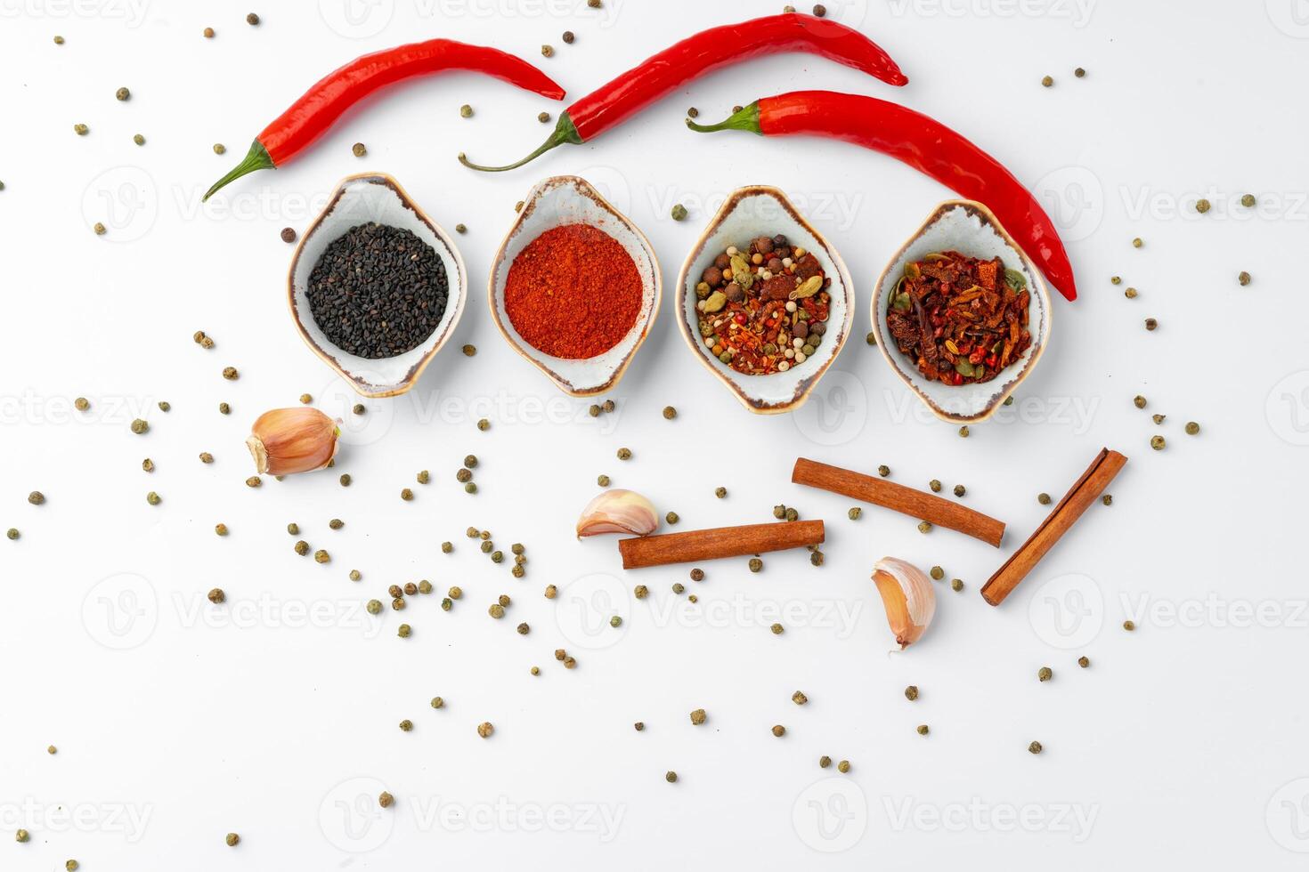 Set of spices in bowls with chili peppers on white background photo