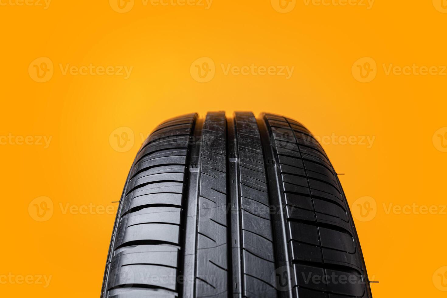 Car tires isolated on yellow background, close up photo