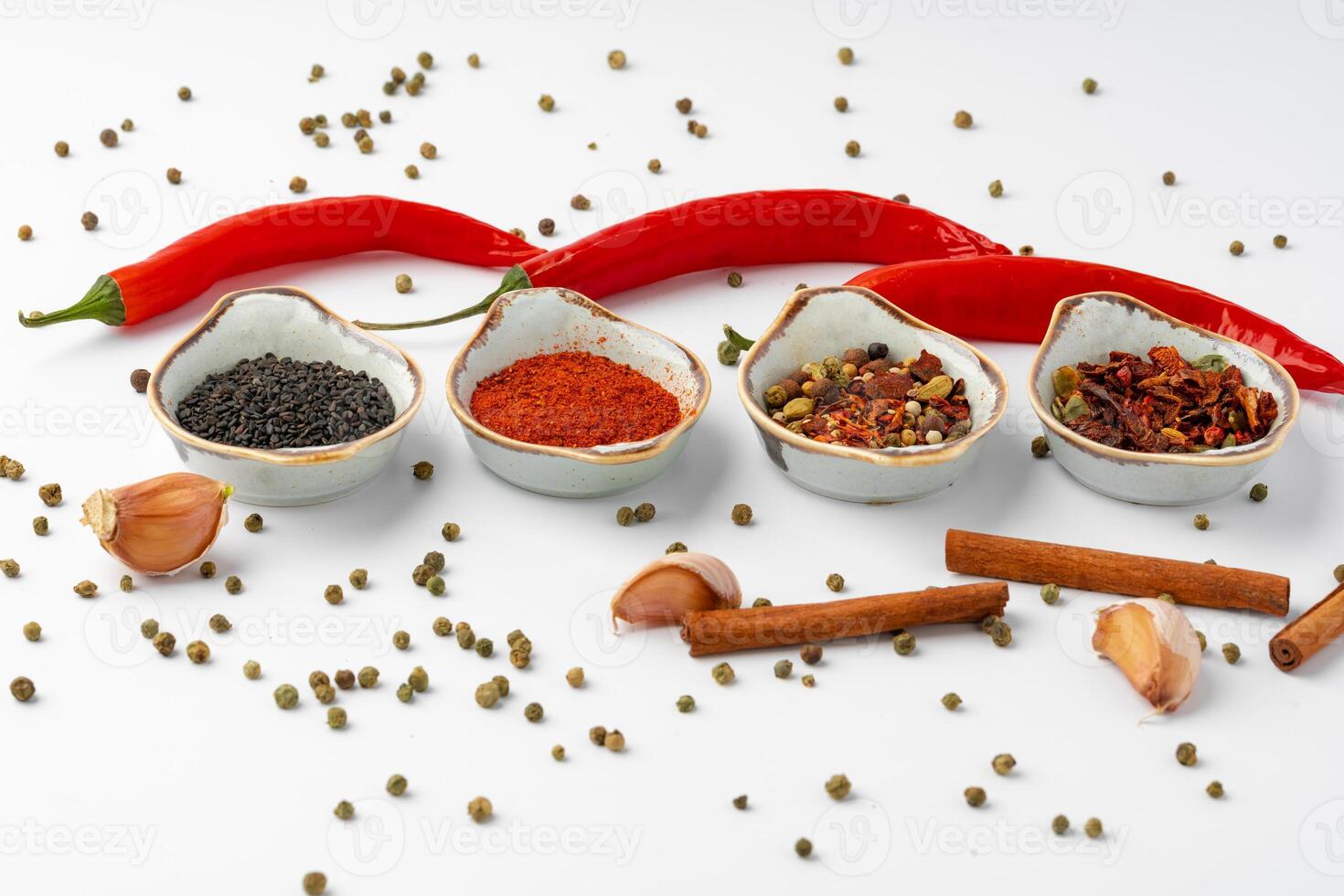 Set of spices in bowls with chili peppers on white background photo