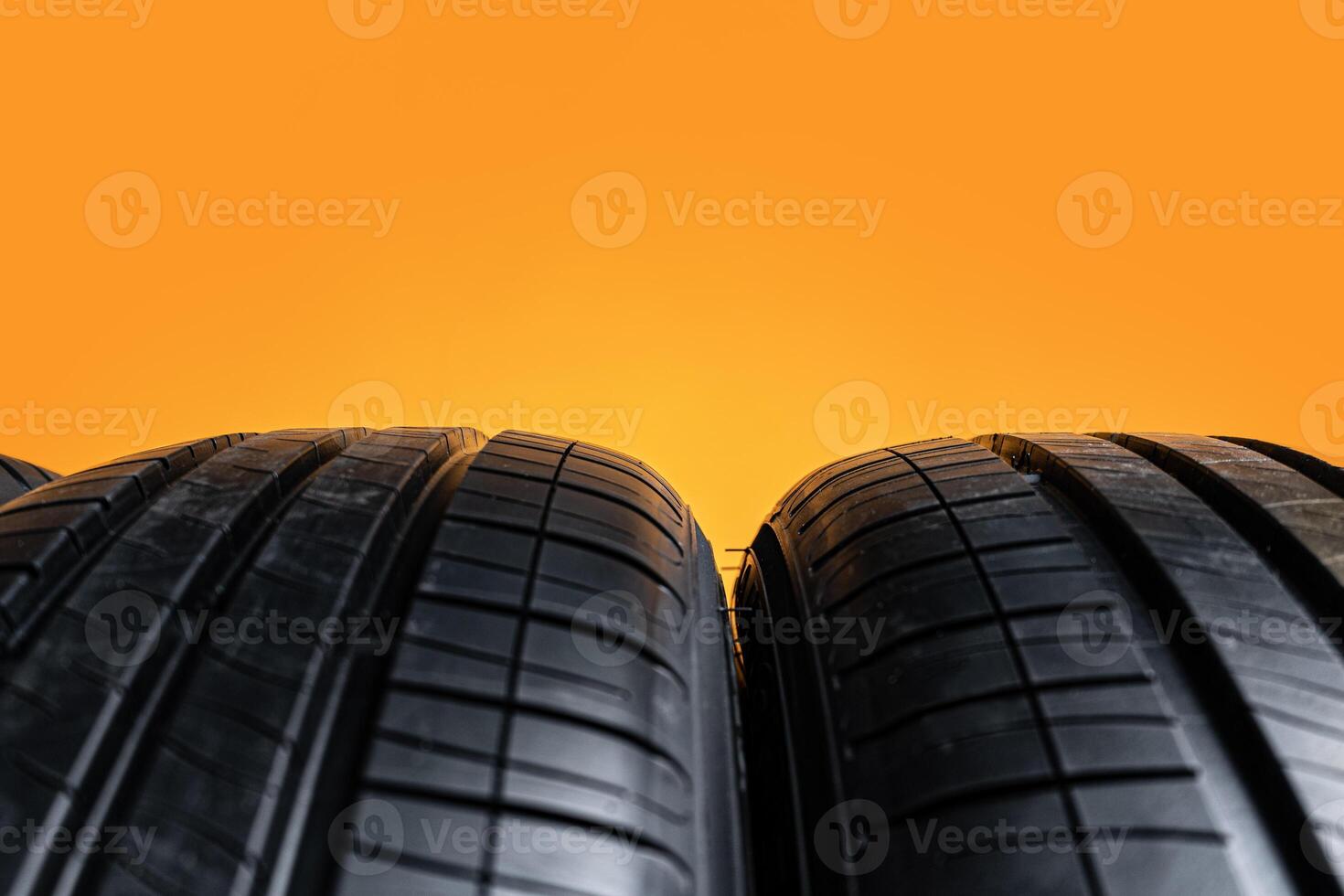 Car tires isolated on yellow background, close up photo