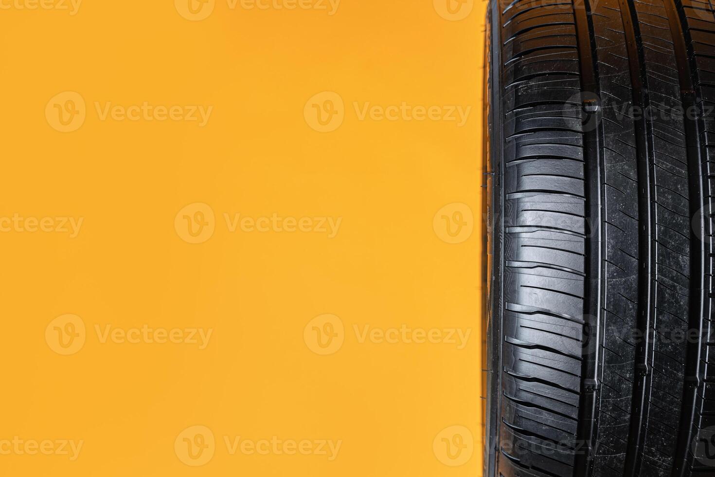 Car tires isolated on yellow background, close up photo
