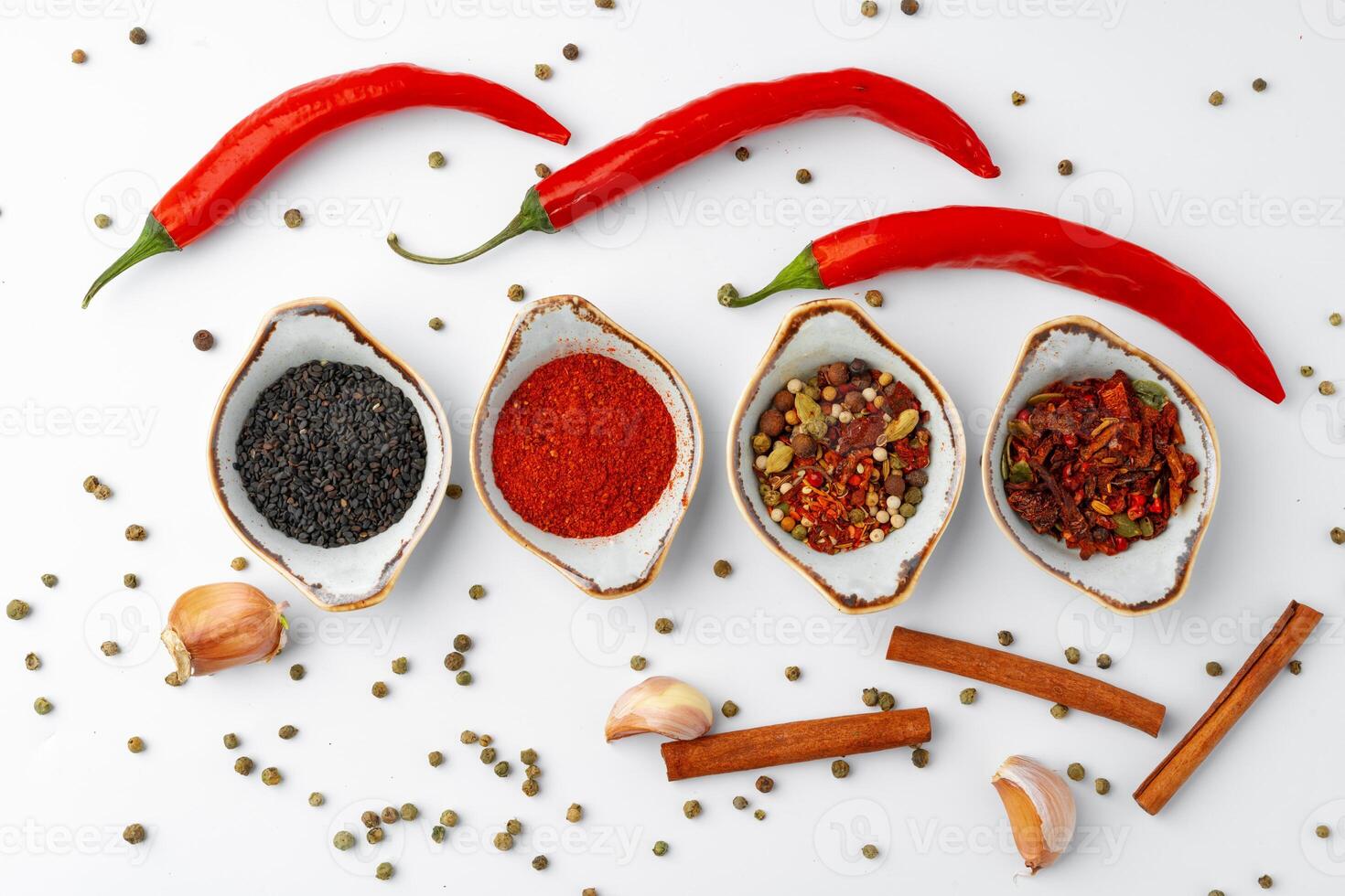 Set of spices in bowls with chili peppers on white background photo