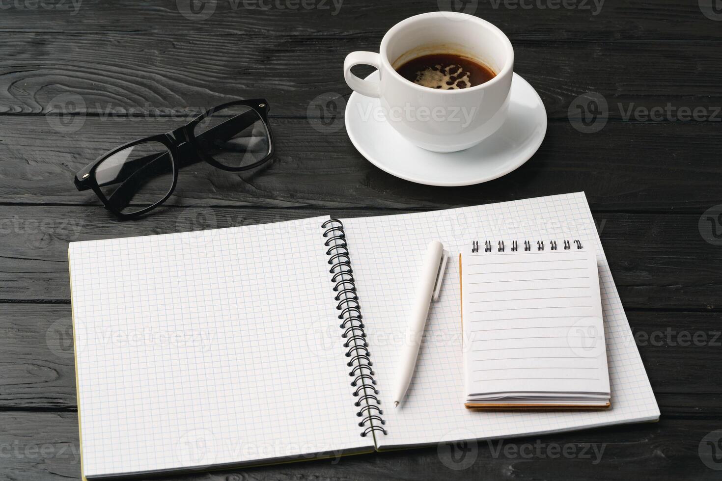 Blank notebook with pen are on top of office desk table photo
