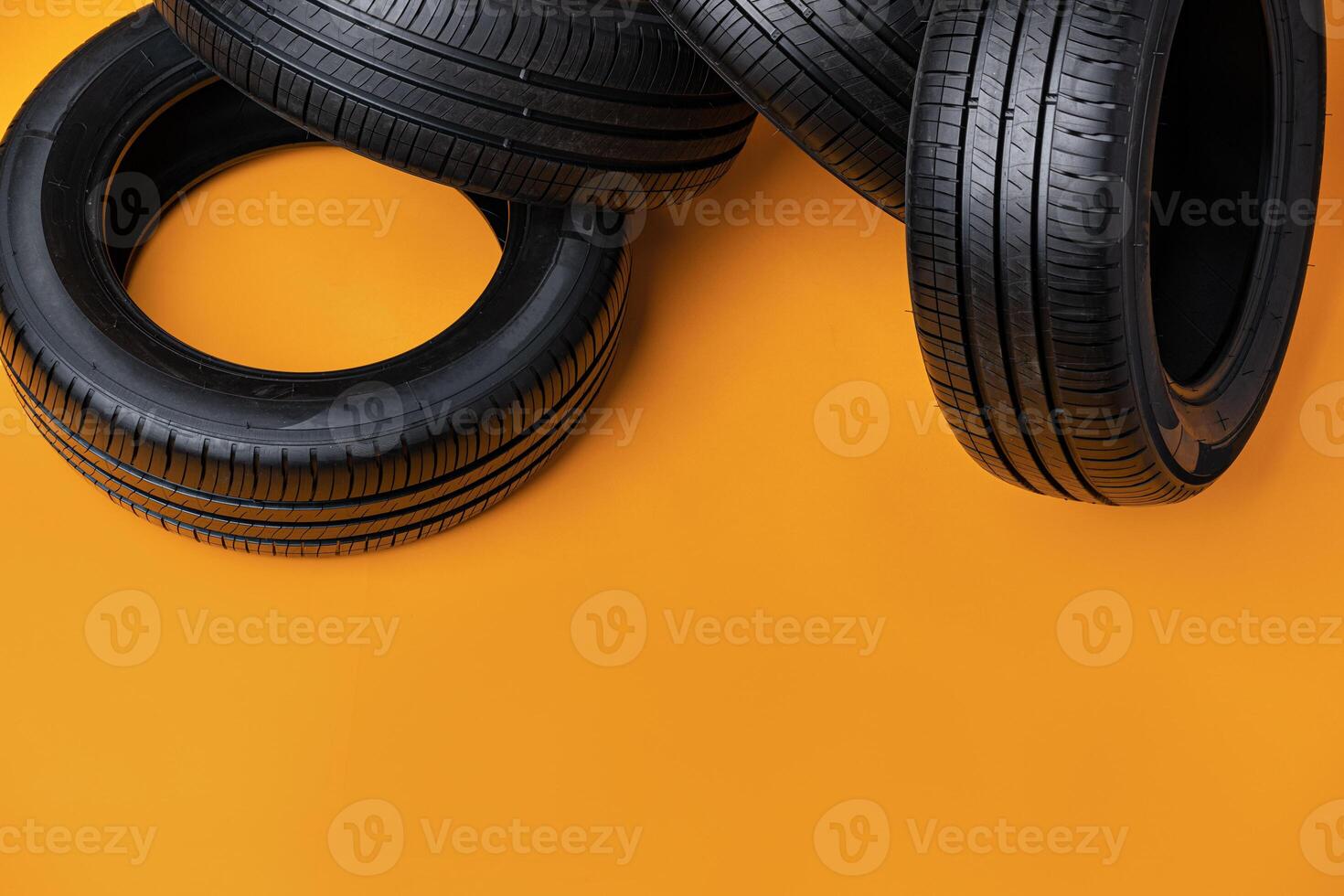 Car tires isolated on yellow background, close up photo