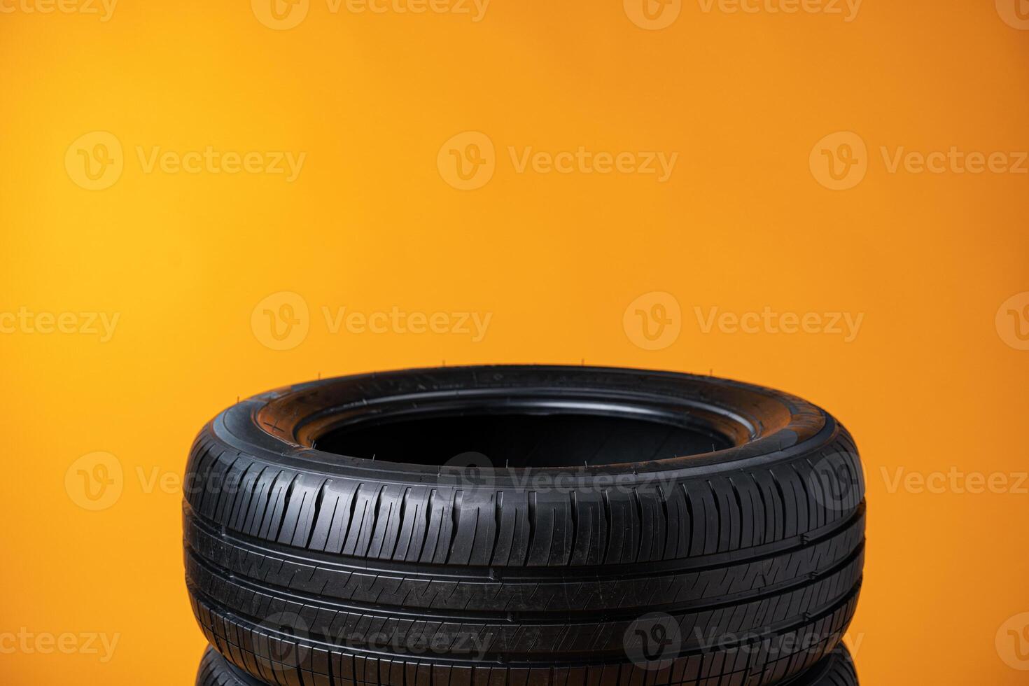 Car tires isolated on yellow background, close up photo