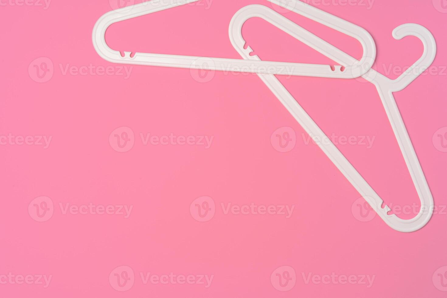 Flat lay composition with empty hangers on pink background photo