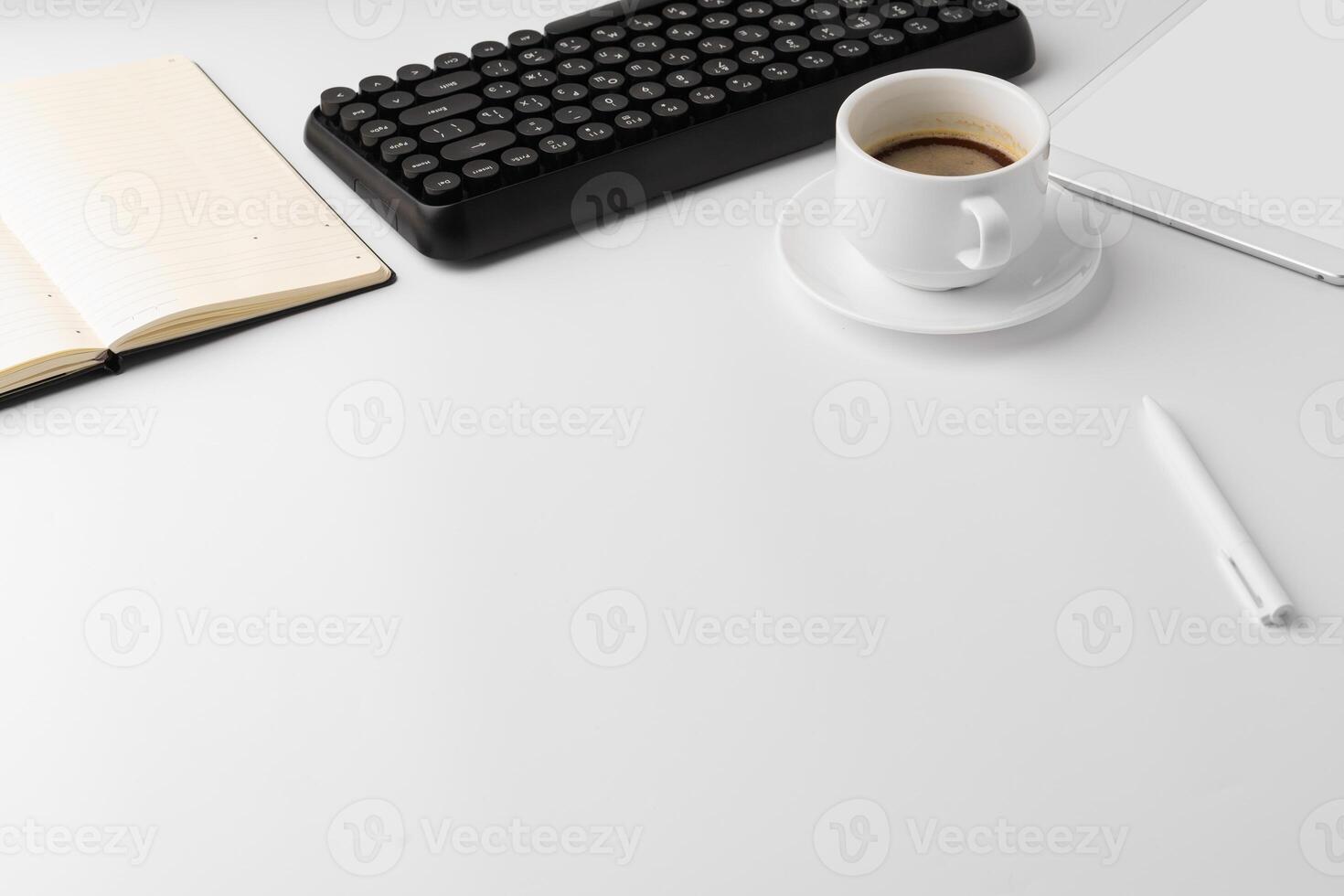 Office desk with laptop, blank notebook and coffee cup photo