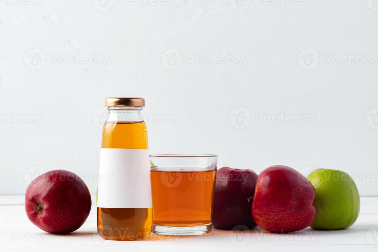 Glass bottle of apple juice with apple fruit on white background photo